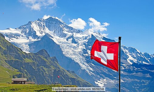 Schweizer Flagge vor Alpenlandschaft